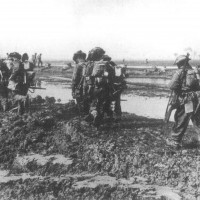1 Aprile  1945. Commandos della marina inglese marciano lungo gli argini meridionali delle valli attraverso le campagne allagate