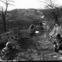 Un Mitragliere e due fucilieri della Compagnia K, 87° Fanteria di Montagna statunitense coprono
una squadra di assalto che cerca di snidare i tedeschi asserragliati nella Casa Campolungo, vicino
Passo Brasa (Castel d'Aiano).