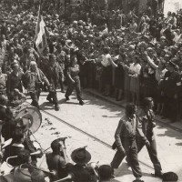 Partigiani feriti assistono dal palco alla sfilata del 9 maggio 1945